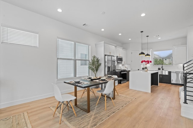 dining area with light hardwood / wood-style flooring and sink