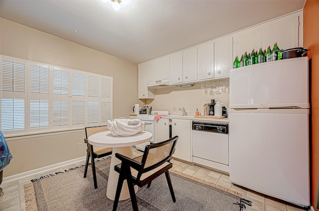 kitchen featuring white cabinets, white appliances, sink, and light tile patterned floors