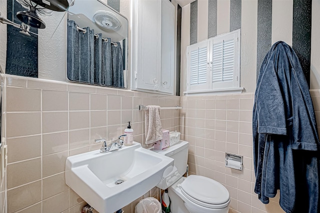 bathroom featuring tile walls, sink, and toilet