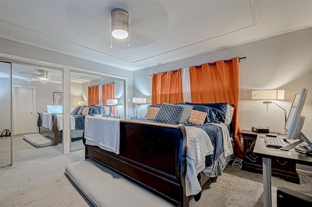 bedroom featuring multiple closets, ceiling fan, crown molding, and light colored carpet