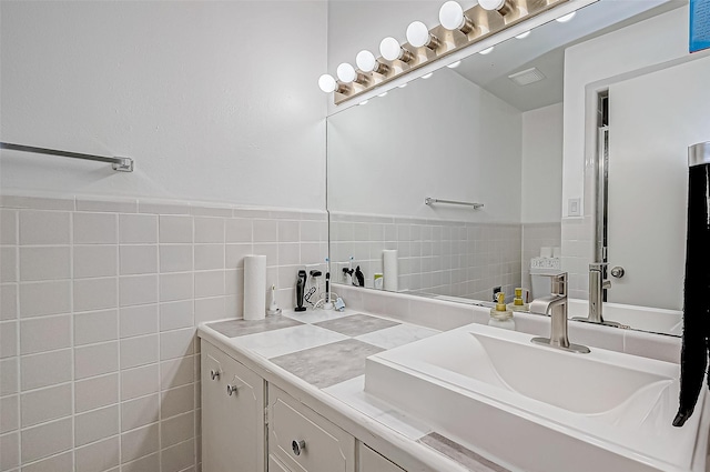 bathroom featuring vanity and tile walls