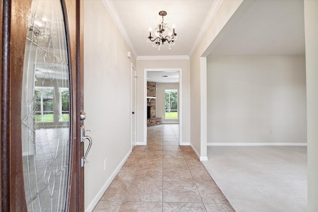 carpeted foyer entrance featuring a chandelier, a fireplace, and crown molding