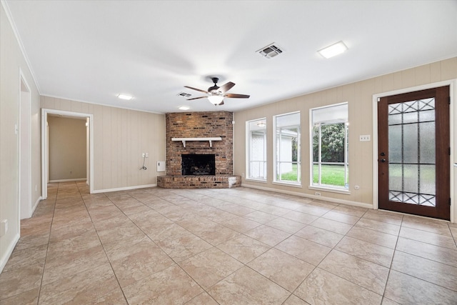 unfurnished living room with crown molding, a fireplace, ceiling fan, and light tile patterned floors