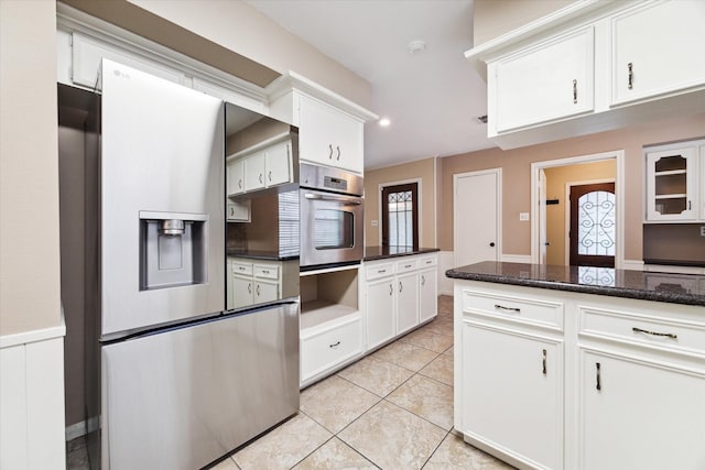 kitchen with dark stone counters, french doors, light tile patterned floors, white cabinetry, and stainless steel appliances