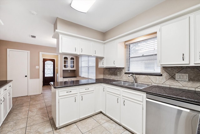 kitchen featuring dishwasher, backsplash, white cabinets, sink, and kitchen peninsula