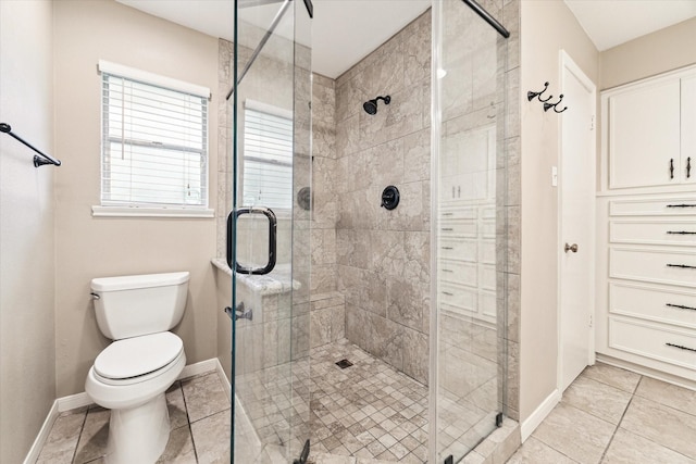 bathroom featuring tile patterned flooring, toilet, and an enclosed shower