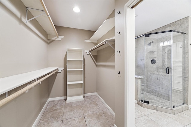 walk in closet with light tile patterned floors