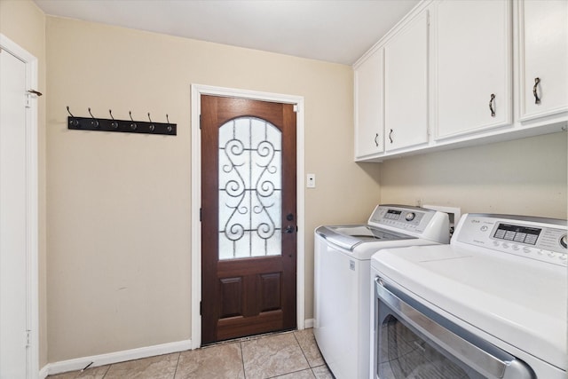 laundry room featuring washer and clothes dryer, light tile patterned flooring, and cabinets