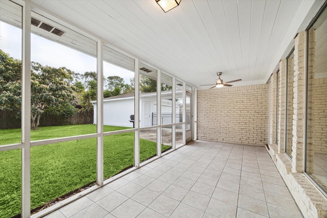 unfurnished sunroom featuring ceiling fan