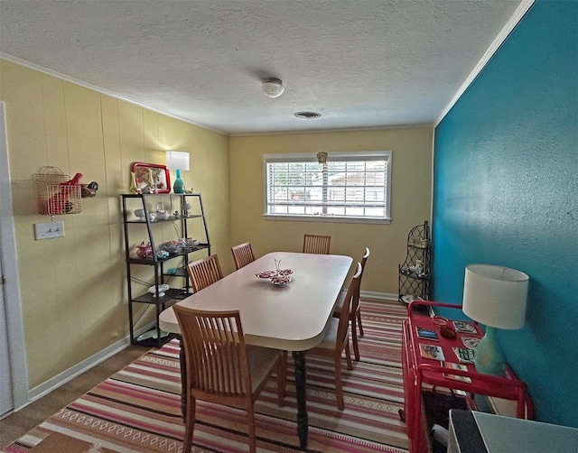 carpeted dining space featuring a textured ceiling and crown molding