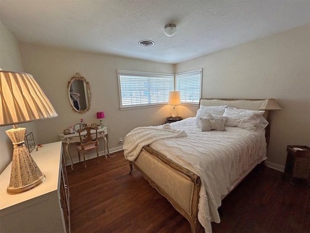 bedroom with dark hardwood / wood-style flooring and a textured ceiling