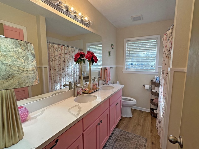 bathroom with hardwood / wood-style floors, vanity, a textured ceiling, and toilet