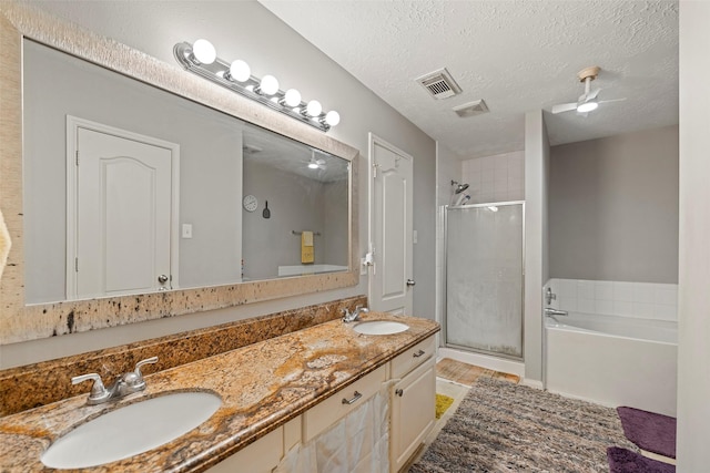 bathroom with vanity, separate shower and tub, and a textured ceiling