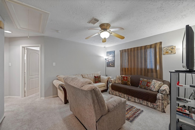 living room featuring ceiling fan, light colored carpet, and a textured ceiling