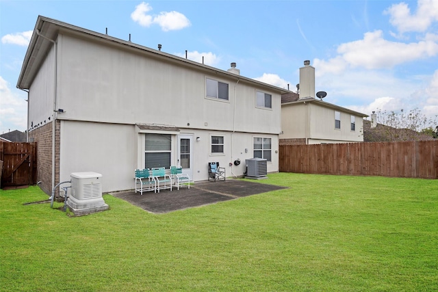 back of property featuring a yard, cooling unit, and a patio area