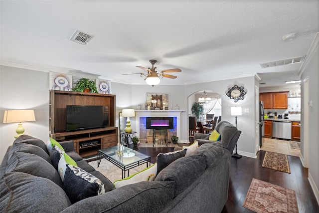 living room featuring ceiling fan with notable chandelier, dark hardwood / wood-style floors, plenty of natural light, and crown molding