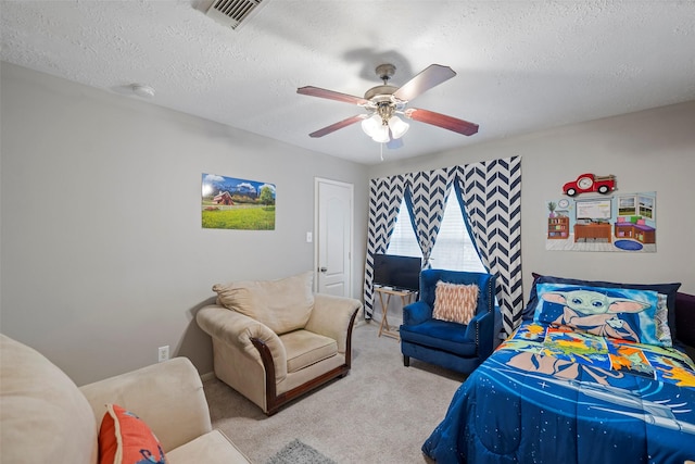 bedroom with ceiling fan, light carpet, and a textured ceiling