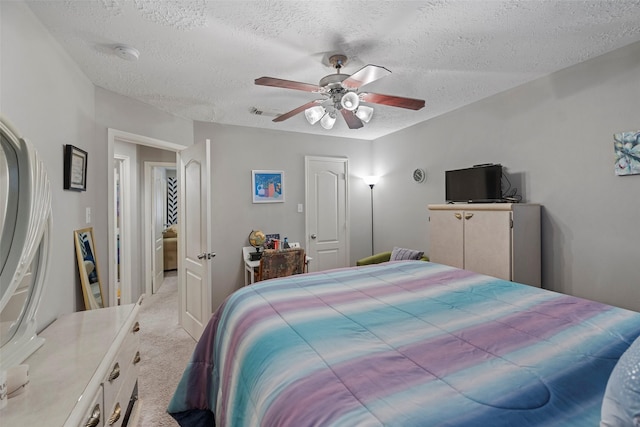 carpeted bedroom featuring a textured ceiling and ceiling fan