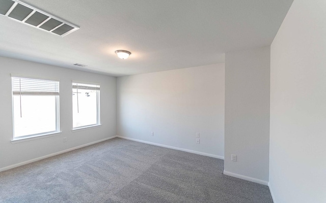 carpeted spare room with visible vents and baseboards