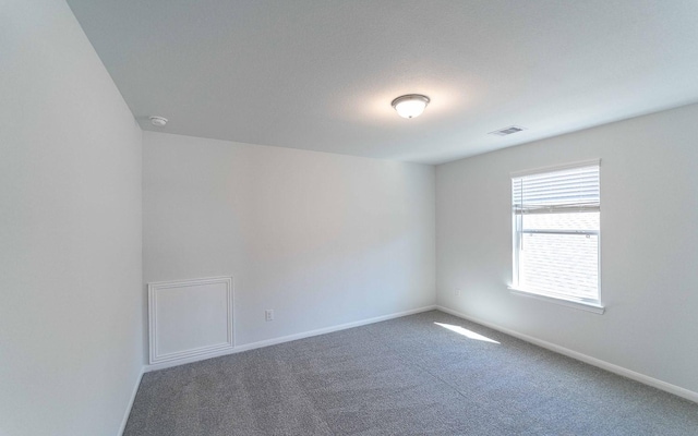 unfurnished room with baseboards, visible vents, and carpet flooring