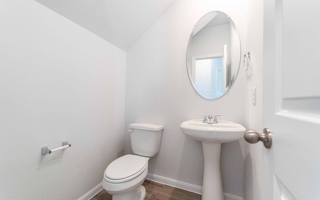 bathroom with a sink, wood finished floors, toilet, and baseboards