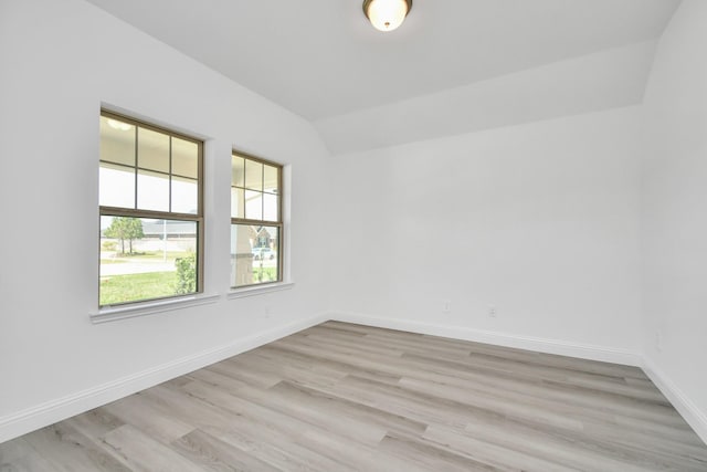 unfurnished room featuring light hardwood / wood-style floors and vaulted ceiling