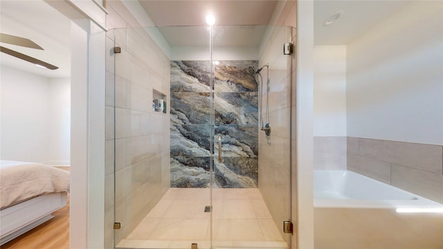 bathroom featuring hardwood / wood-style floors, ceiling fan, and shower with separate bathtub