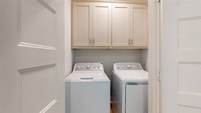 laundry room featuring cabinets and washing machine and clothes dryer