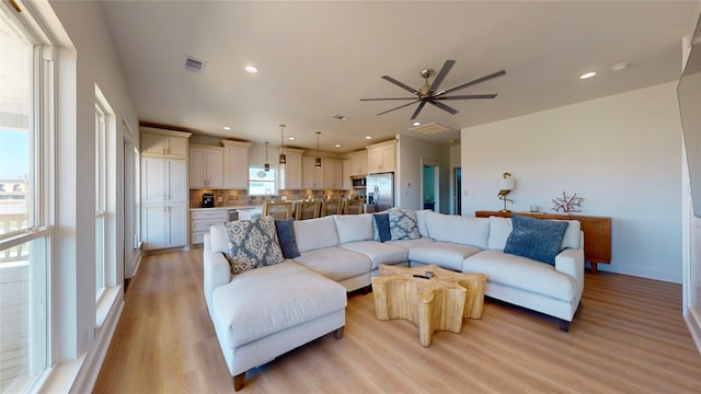 living room featuring ceiling fan and light wood-type flooring