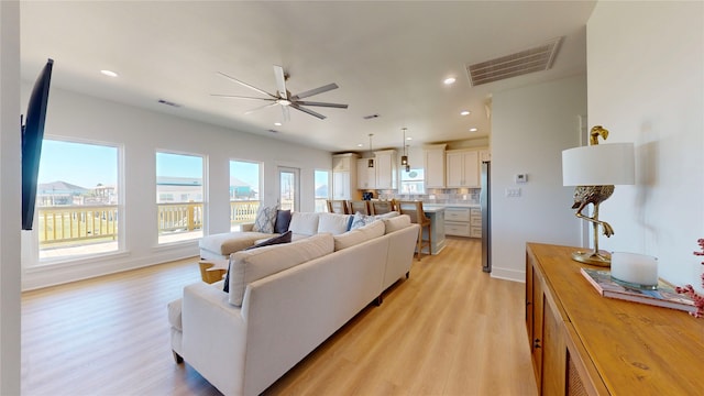 living room with ceiling fan and light wood-type flooring