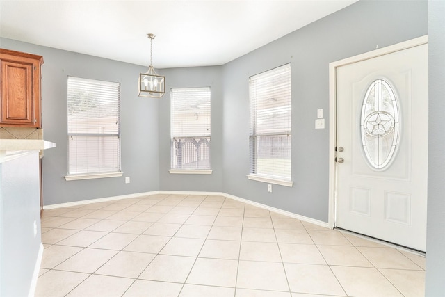 entryway with light tile patterned floors and a chandelier