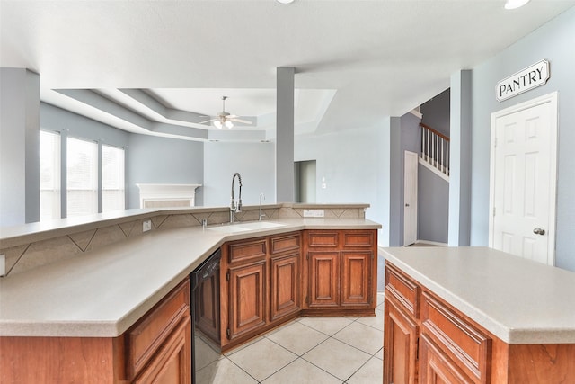 kitchen featuring light tile patterned flooring, sink, ceiling fan, black dishwasher, and a kitchen island