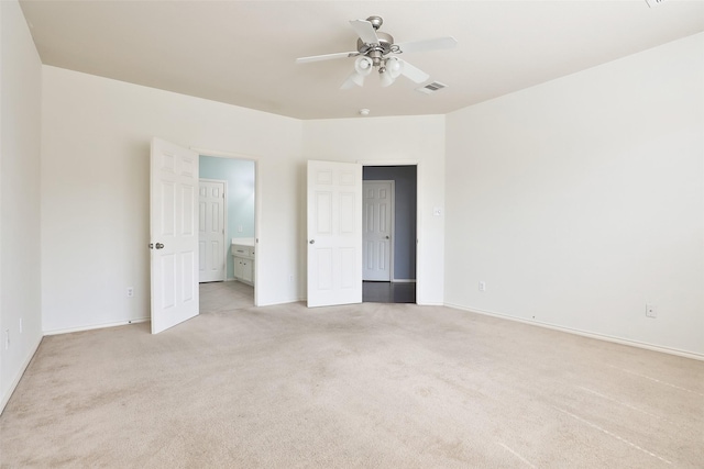 unfurnished bedroom with light carpet, ensuite bathroom, and ceiling fan