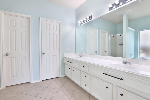 bathroom with tile patterned flooring, vanity, and a shower with door