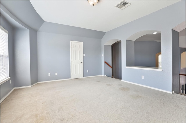 carpeted empty room with lofted ceiling