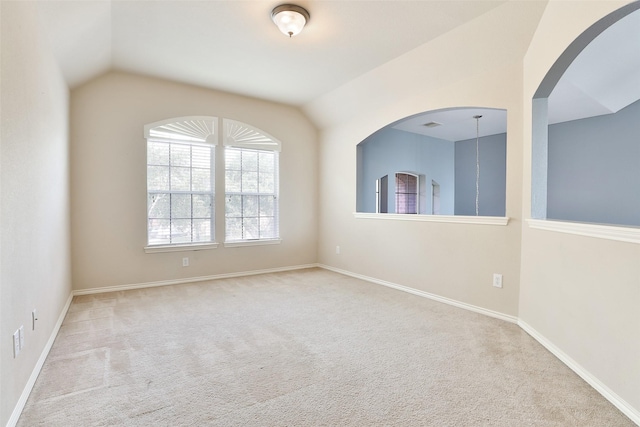 unfurnished room featuring light carpet and lofted ceiling