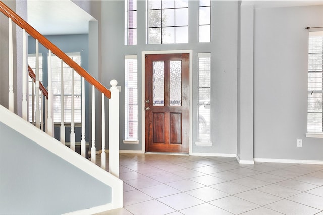 foyer entrance featuring light tile patterned floors and a high ceiling