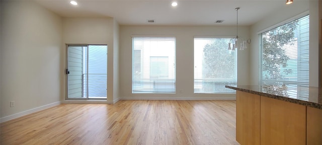 interior space with a notable chandelier and light hardwood / wood-style floors