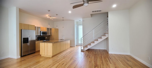 kitchen featuring pendant lighting, sink, light hardwood / wood-style flooring, ceiling fan, and appliances with stainless steel finishes