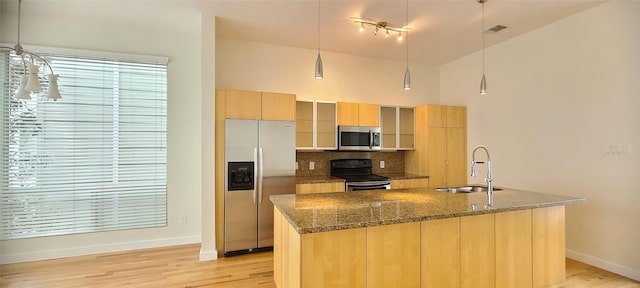 kitchen featuring pendant lighting, sink, appliances with stainless steel finishes, and light hardwood / wood-style flooring