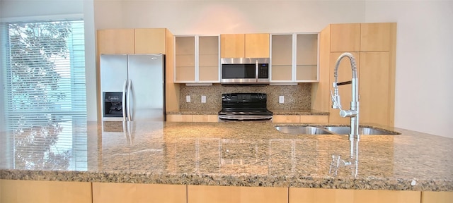 kitchen featuring light brown cabinets, backsplash, sink, appliances with stainless steel finishes, and light stone counters