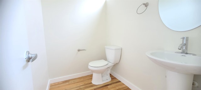 bathroom featuring hardwood / wood-style floors, toilet, and sink