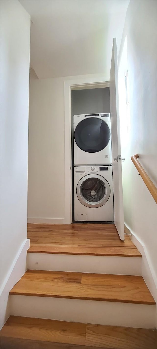 stairway featuring stacked washer / drying machine