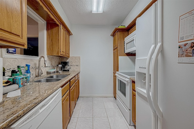 kitchen featuring backsplash, sink, a textured ceiling, and white appliances