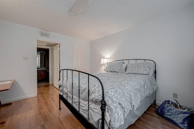 bedroom featuring wood-type flooring and a textured ceiling