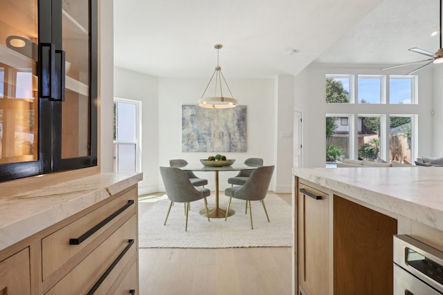 dining area featuring light wood-type flooring and ceiling fan