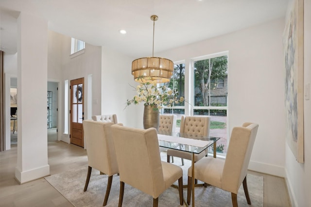 dining room with light hardwood / wood-style floors and an inviting chandelier