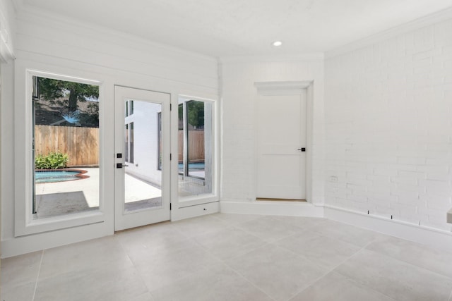 unfurnished room with light tile patterned flooring and ornamental molding