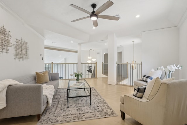 living room with ceiling fan, crown molding, and light hardwood / wood-style flooring