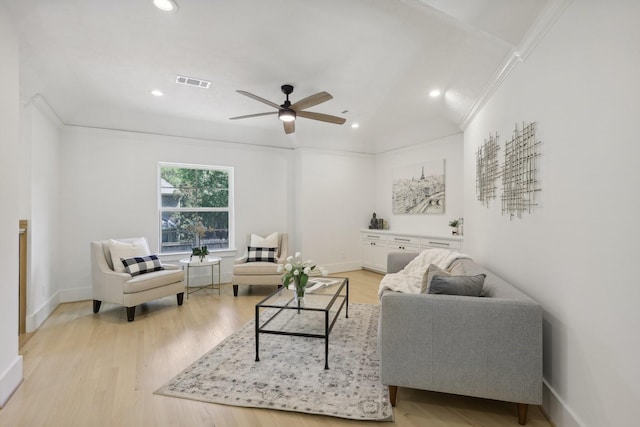 living room featuring ceiling fan, light wood-type flooring, and ornamental molding